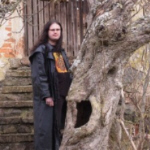 Andr J.C. Bor before entrance to the monastery, with the wicked tree....